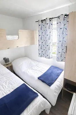 Un ou plusieurs lits dans un hébergement de l'établissement Mobil-home cosy climatisé 5 pers - Terrasse couverte - Plage des Casernes à 800m