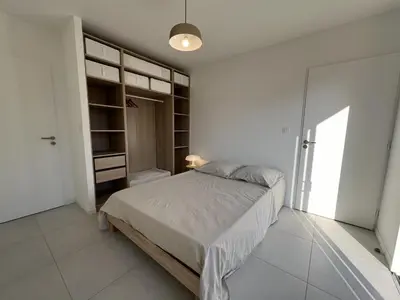 Un ou plusieurs lits dans un hébergement de l'établissement Maison en bois avec piscine proche de la plage