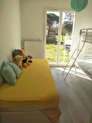 Un ou plusieurs lits dans un hébergement de l'établissement Maison charmante à Mimizan avec vue sur jardin et terrasses
