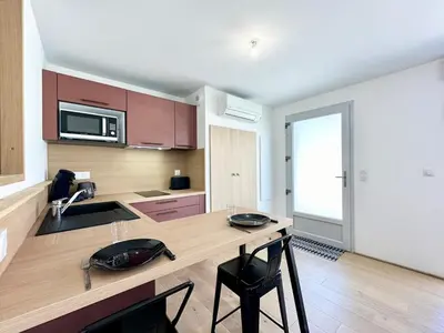 Cuisine ou kitchenette dans l'établissement Sous les Palmiers - Neuf - Parking - Centre - Télé