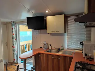 Cuisine ou kitchenette dans l'établissement Mobil home climatisé confort