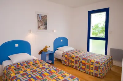 Un ou plusieurs lits dans un hébergement de l'établissement Madame Vacances Villas Club Royal Aquitaine