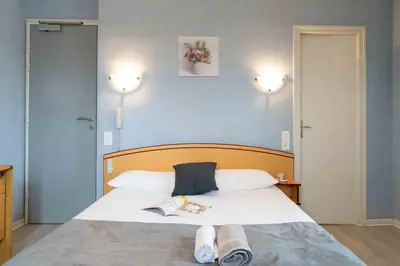 Un ou plusieurs lits dans un hébergement de l'établissement Logis Hôtel La crémaillère