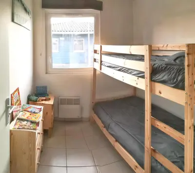 Un ou plusieurs lits superposés dans un hébergement de l'établissement Maison confortable à Parentis-en-Born avec piscine partagée