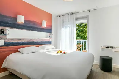 Un ou plusieurs lits dans un hébergement de l'établissement Les Vagues Logis Hôtel