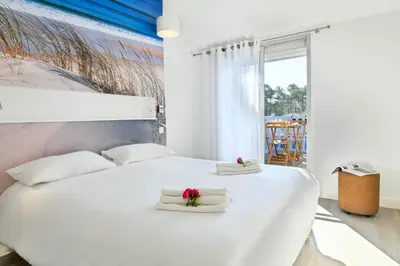 Un ou plusieurs lits dans un hébergement de l'établissement Les Vagues Logis Hôtel