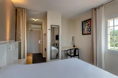 Un ou plusieurs lits dans un hébergement de l'établissement Logis Hôtel de L'Océan